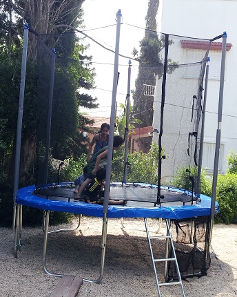 ילדים קופצים על טרמפולינה בחצר ילדים קופצים על טרמפולינה בחצר